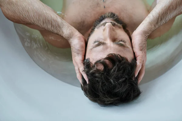 Депрессивный травмированный человек с бородой, лежащий в ванне во время поломки, психическое здоровье осведомленности — стоковое фото