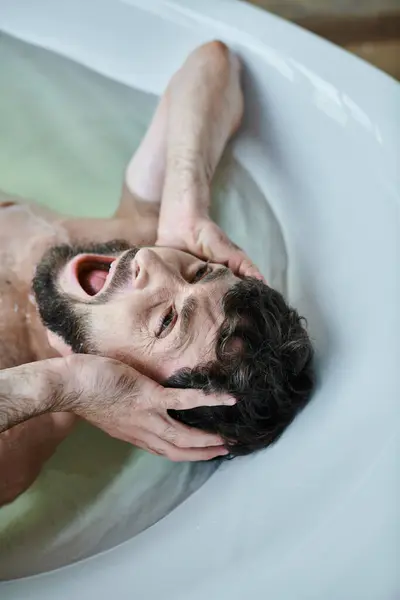 Emotional traumatized man lying in bathtub  and screaming during breakdown, mental health awareness — Stock Photo