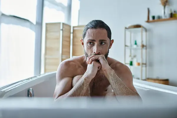 Тревожный депрессивный человек с бородой, сидящий в ванне во время срыва, психического здоровья осведомленности — стоковое фото