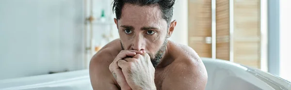 Homme malade assis dans la baignoire avec les mains près du visage pendant la dépression, sensibilisation à la santé mentale, bannière — Photo de stock