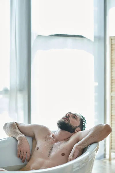 Traumatizzato uomo frustrato con la barba sdraiato nella vasca da bagno durante il crollo, consapevolezza della salute mentale — Foto stock