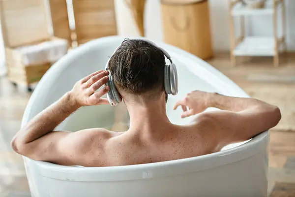 Vista posteriore del modello maschile seduto e rilassante attivamente nella sua vasca da bagno, consapevolezza della salute mentale — Foto stock