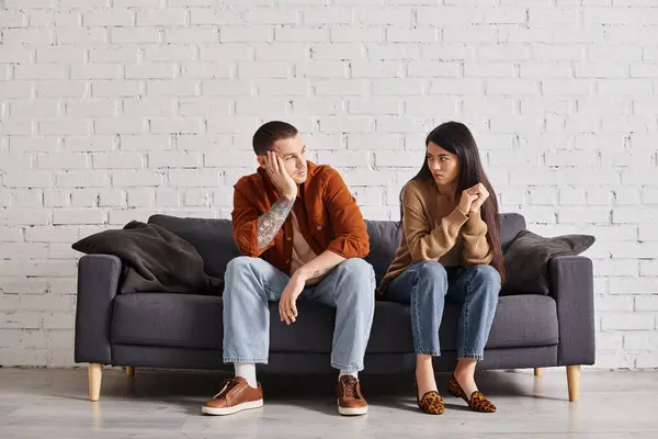 Coppia interrazziale con difficoltà di relazione parlando sul divano in soggiorno, concetto di divorzio — Foto stock