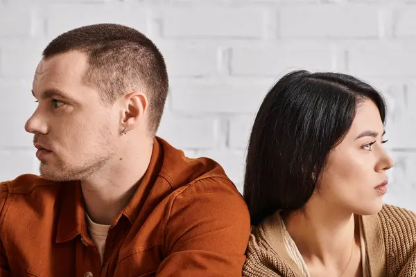 Offensé couple interracial assis dos à dos et regardant loin dans le salon, concept de divorce — Photo de stock