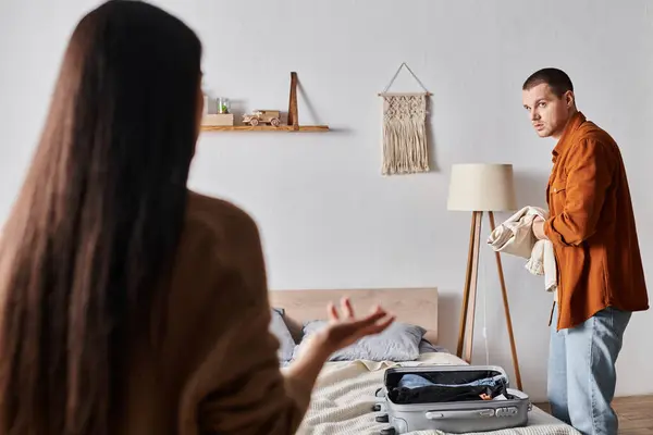 Jeune femme parlant au mari offensé valise dans la chambre à coucher, difficultés relationnelles — Photo de stock