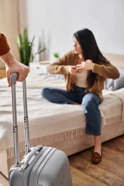 Young gloomy asian woman taking off wedding near husband with suitcase leaving home, family divorce — Stock Photo