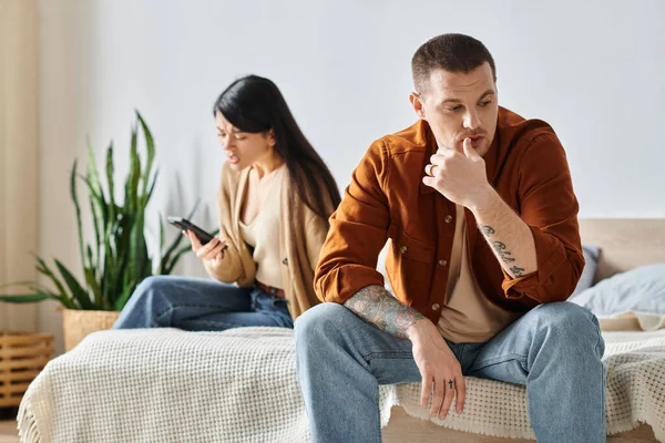 Scioccato asiatico donna guardando smartphone vicino sconvolto marito in camera da letto ta casa, fraintendimento — Foto stock