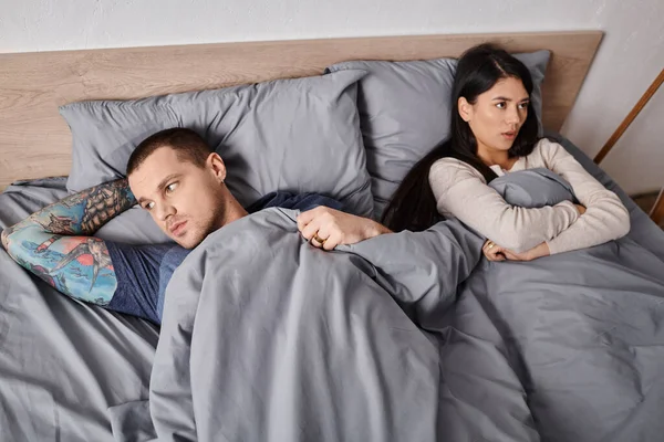 High-Winkel-Ansicht von jungen interrassischen beleidigten Paar liegend auf dem Bett zu Hause, Beziehungsprobleme — Stockfoto