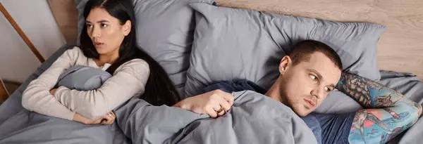 Vista de ángulo alto de la pareja ofendida multiétnica acostada en la cama en casa, pancarta horizontal - foto de stock