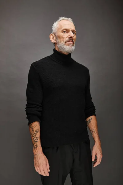 Handsome fashionable mature man with beard in elegant black turtleneck posing and looking at camera — Stock Photo