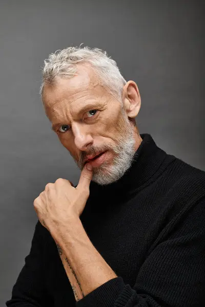 Appealing fashionable mature man with beard in trendy black turtleneck posing and looking at camera — Stock Photo