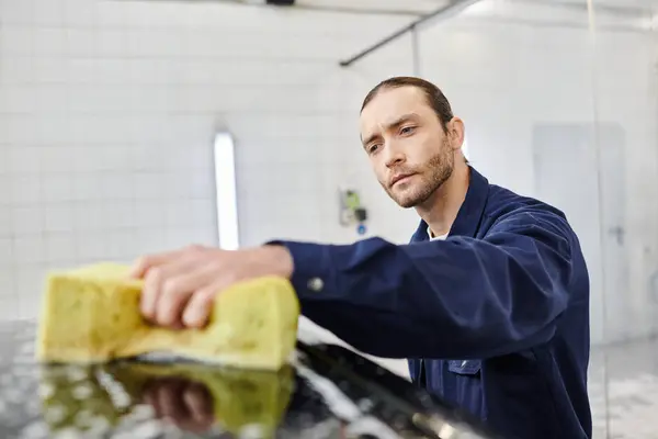 Bon spécialiste de travail dur en uniforme bleu avec voiture de nettoyage de cheveux collecté avec éponge — Photo de stock