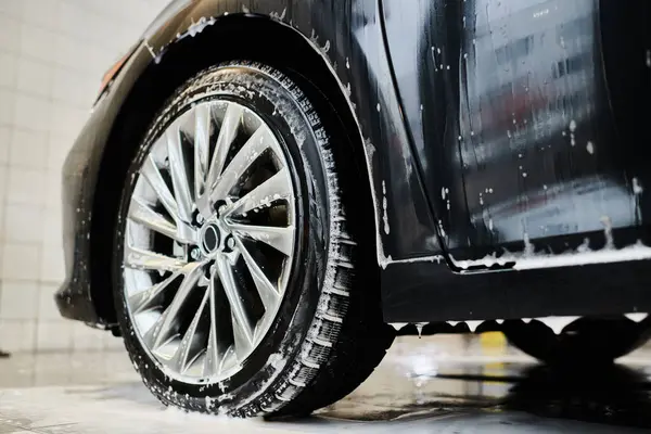 Objet photo de brillant fatigué de noir moderne automobile recouvert de savon pendant le service de détail de voiture — Photo de stock