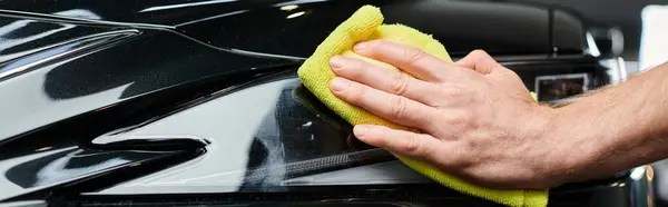 Cropped view of professional dedicated serviceman using rag to clean black modern car, banner — Stock Photo