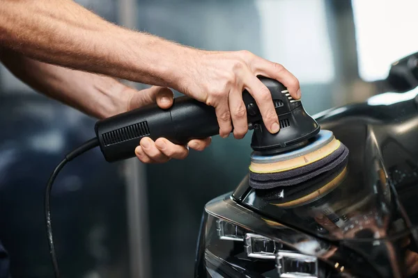 Visão recortada de profissional dedicado usando máquina de polimento com cuidado no carro moderno preto — Fotografia de Stock