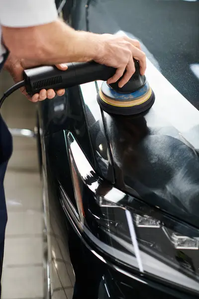Cropped view of dedicated professional serviceman using polishing machine on black modern car — Stock Photo