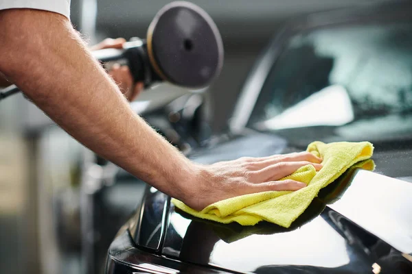 Vista ritagliata di auto di pulizia professionale dedicata con straccio e macchina di lucidatura tenuta — Foto stock