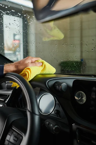 Ausgeschnittene Ansicht des hart arbeitenden professionellen Servicemanns, der das Handschuhfach mit gelbem Lappen reinigt — Stockfoto