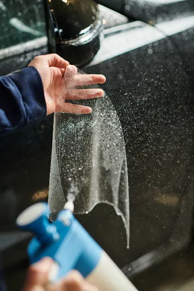 Cropped view of hard working serviceman in uniform applying protective foil on side view mirror — Stock Photo