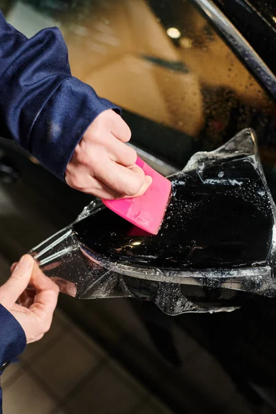 Cropped vie of devoted hard working serviceman applying protective foil on side view mirror — Stock Photo