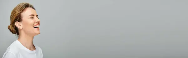 Joyous appealing woman with blonde hair posing on gray backdrop and laughing sincerely, banner — Stock Photo