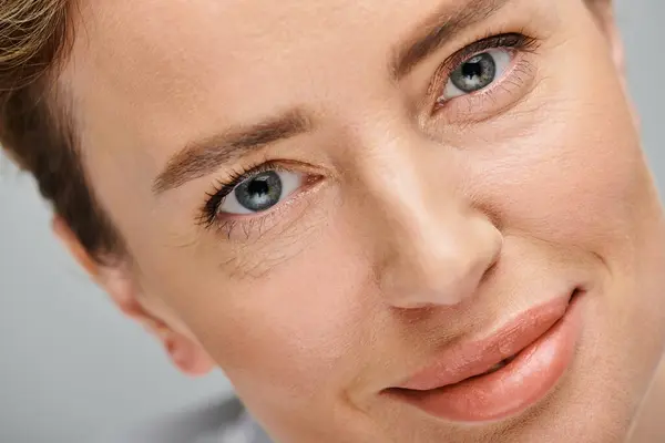 Nahaufnahme einer fröhlich schönen Frau mit blonden Haaren und Kontaktlinsen, die in die Kamera schaut — Stockfoto