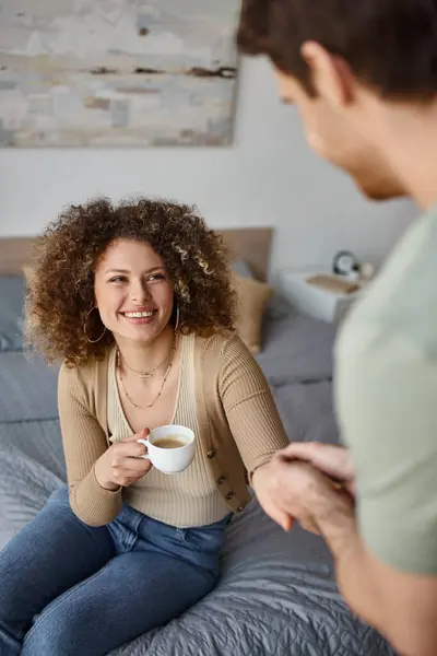 Morning coffee and lovely time with curly young woman and brunette man, smiling conversation - foto de stock