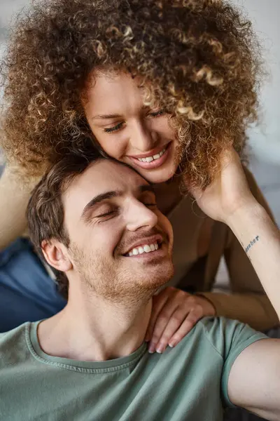 Loving couple, curly young woman and brunette man, hugging tightly with happy smiles — Stock Photo