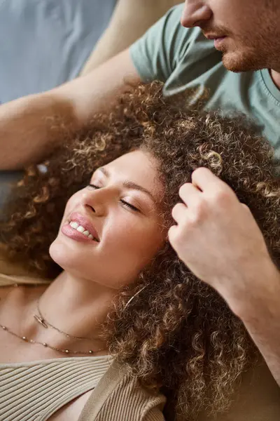 Closeup image of man touching his girlfriend hair in bed, smiling and enjoying time together at home — Stock Photo
