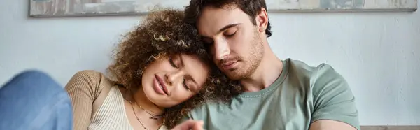 In their cozy bedroom, curly young woman and brunette man sharing a heartfelt hug, banner - foto de stock