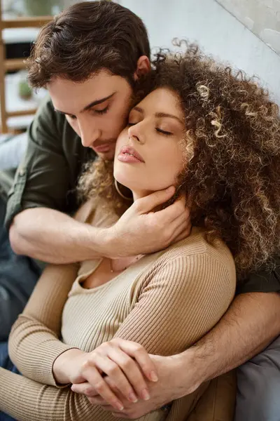 Die lockige junge Frau und der brünette Mann umarmen sich gegenseitig und genießen einen friedlichen Morgen — Stockfoto