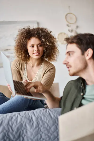 Couple in love spending time together in bed, woman showing laptop screen to man — Stock Photo