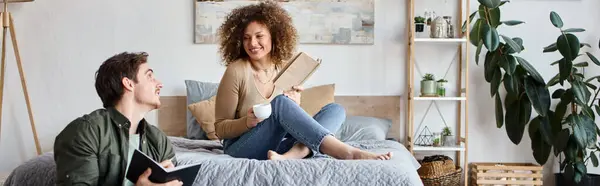 Couple working at home. Woman reading book on bed and man is working sitting on the floor, banner — Stock Photo