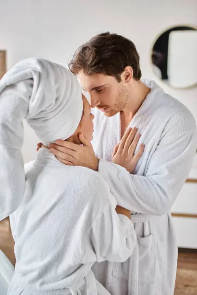 Atractiva pareja enamorada en el baño abrazándose y abrazándose, hombre tocando el cuello de su novia - foto de stock
