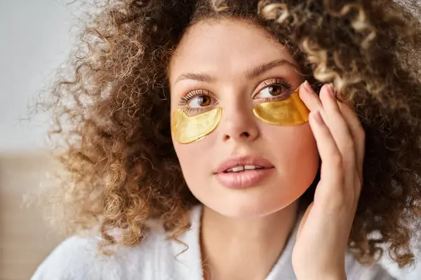 Closeup portrait of curly beautiful young  woman with eye patches  touching cheek and looking away — Stock Photo