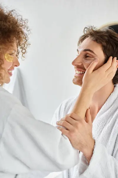 Side view portrait of couple with eye patches  hugging in bathroom and smiling, bonding — Stock Photo