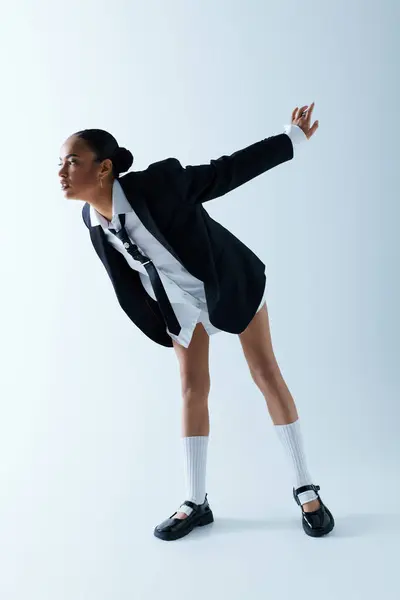 Junge Afroamerikanerin in ihren Zwanzigern trägt einen schwarz-weißen Anzug und weiße Socken. — Stockfoto