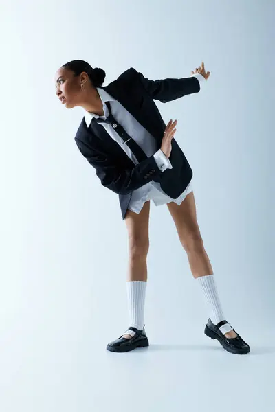Confident young African American woman strikes a pose in a suit and white socks. — Stock Photo