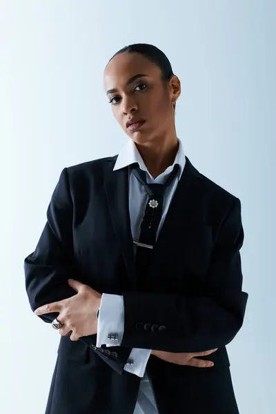 A young African American woman in her 20s confidently poses in a suit and tie for a photo. — Stock Photo