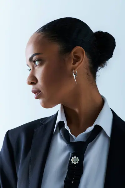 Giovane donna afroamericana trasuda raffinatezza in cravatta nera e camicia bianca. — Foto stock
