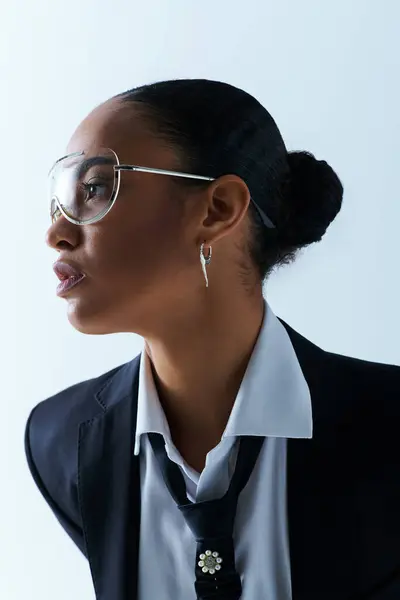 Young African American woman in her 20s, wearing a suit and tie with glasses. — Stock Photo