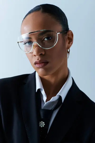 Giovane donna afroamericana sicura di sé che indossa occhiali e un vestito in un ambiente da studio. — Foto stock