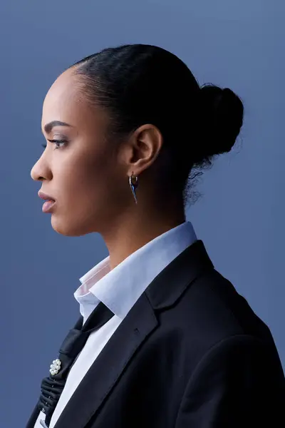 Giovane donna afroamericana in giacca e cravatta guarda pensieroso al lato. — Foto stock