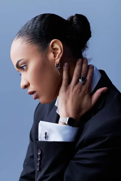 Una giovane donna afroamericana in un abito elegante, ascoltando attentamente con la mano all'orecchio. — Foto stock