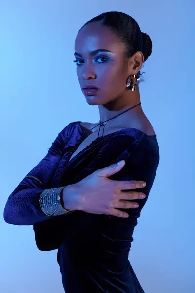 Uma jovem afro-americana está confiante em um estúdio, vestindo um vestido preto com os braços cruzados. — Fotografia de Stock