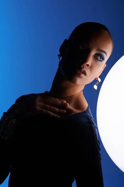 An African American woman holds a large white object, radiating awe and curiosity. — Stock Photo
