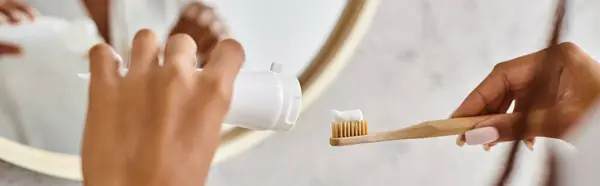 Nahaufnahme einer afroamerikanischen Frau im Bademantel, die sich in einem modernen Badezimmer fleißig die Zähne putzt. — Stockfoto