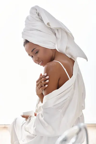 Femme afro-américaine enveloppée dans une serviette après un bain, incarnant la beauté et l'hygiène. — Photo de stock