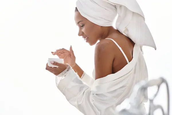 Mulher afro-americana envolta em uma toalha após um banho, incorporando beleza e higiene. — Fotografia de Stock