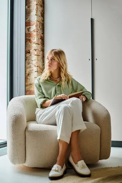 Une femme assise sur une chaise devant une fenêtre dans un appartement. — Photo de stock